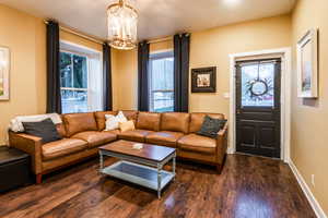 Living room with an inviting chandelier and dark hardwood flooring