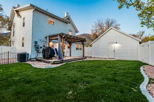 Backyard featuring a patio, a yard, central AC unit, and a pergola