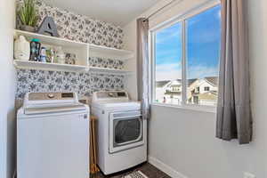 Washroom featuring dark tile patterned floors and washing machine and dryer