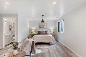 Bedroom with light hardwood / wood-style flooring and ensuite bathroom