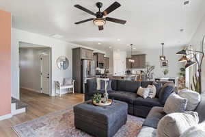 Living room with sink, light hardwood / wood-style flooring, and ceiling fan