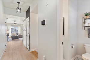 Hallway with light hardwood / wood-style flooring