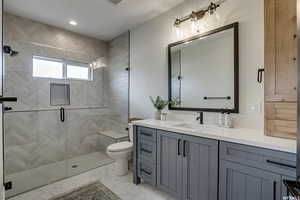 Bathroom featuring vanity, toilet, tile patterned floors, and walk in shower