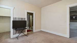 Carpeted living room featuring a textured ceiling