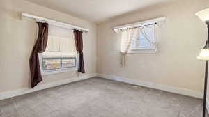 Carpeted spare room with a textured ceiling