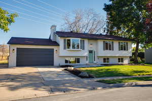 Split foyer home featuring a front yard and a garage