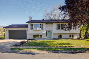 Split foyer home with a front yard and a garage