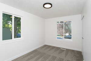 Carpeted empty room with a textured ceiling