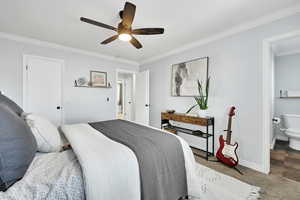 Bedroom with carpet flooring, ensuite bathroom, ceiling fan, and crown molding