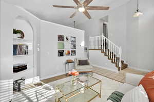 Tiled living room with ceiling fan and lofted ceiling