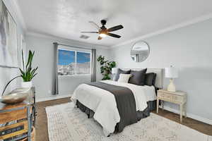 Bedroom with carpet floors, ceiling fan, and crown molding