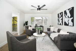 Living room featuring a textured ceiling, hardwood / wood-style flooring, a wealth of natural light, and ceiling fan