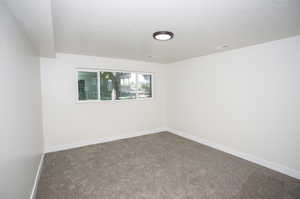 Carpeted spare room featuring a textured ceiling