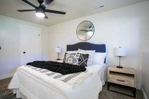 Bedroom featuring ceiling fan and dark carpet