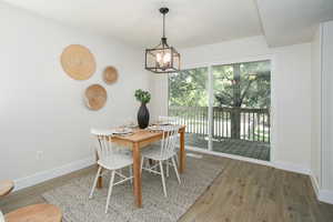 Dining area with a notable chandelier and dark hardwood / wood-style floors