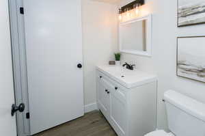 Bathroom featuring toilet, hardwood / wood-style flooring, and vanity