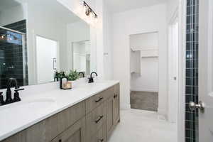 Bathroom featuring vanity, an enclosed shower, and tile patterned flooring