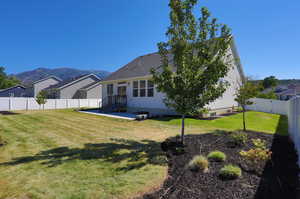 Rear view of house with a yard and a mountain view