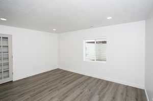 Spare room with a textured ceiling and dark hardwood / wood-style flooring