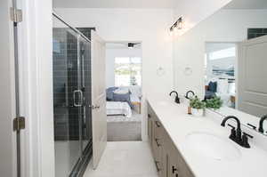 Bathroom with a shower with door, vanity, and tile patterned flooring