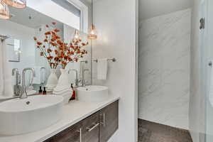 Bathroom featuring vanity and a tile shower