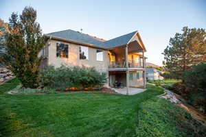 Rear view of property with a balcony, a yard, and a patio area