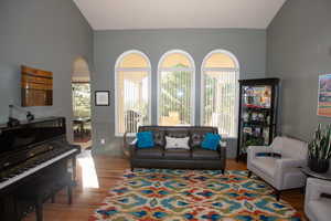 Living room with vaulted ceiling and light wood-type flooring