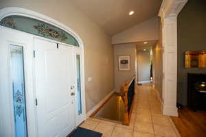 Tiled foyer entrance with vaulted ceiling