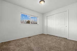 Unfurnished bedroom with carpet and a closet