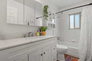 Full bathroom featuring vanity, wood-type flooring, toilet, and shower / bath combo with shower curtain