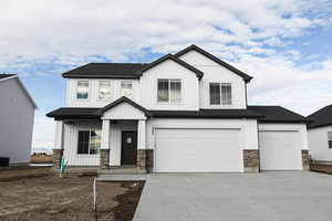 View of front facade with central AC unit and a garage