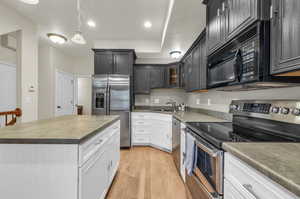 Kitchen featuring sink, appliances with stainless steel finishes, light hardwood flooring, and white cabinets