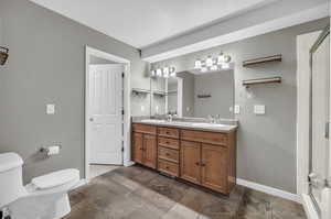 Bathroom with a shower with door, vanity, a textured ceiling, and toilet