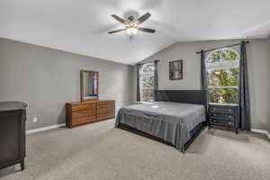 Bedroom featuring carpet, vaulted ceiling, and ceiling fan