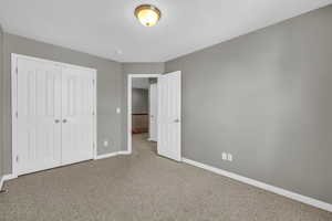 Unfurnished bedroom with a closet and carpet flooring