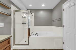 Bathroom featuring vanity and separate shower and tub