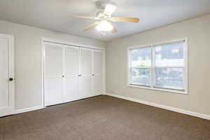 Unfurnished bedroom with carpet, ceiling fan, and a closet