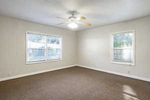 Carpeted spare room featuring ceiling fan