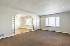 Unfurnished room featuring a textured ceiling, hardwood / wood-style flooring, and ceiling fan