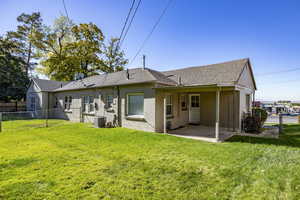 Back of house with a lawn, central AC, and a patio