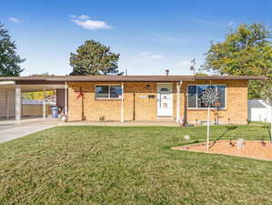 Single story home with a carport and a front lawn