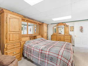 Carpeted bedroom featuring a drop ceiling