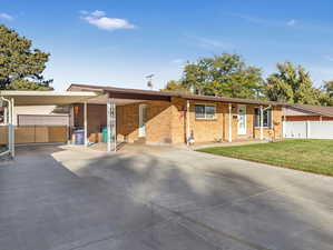 Single story home with a carport and a front yard