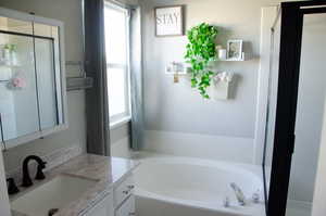 Primary Bathroom with vanity and a tub to relax in