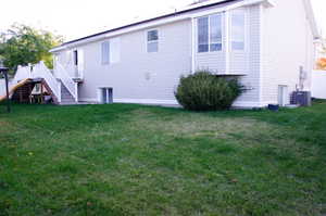 Rear view of house with a deck and a yard