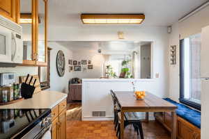 Kitchen with parquet floors, decorative light fixtures, and electric range