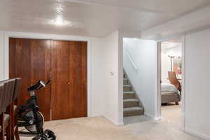 Exercise room featuring a textured ceiling and light colored carpet