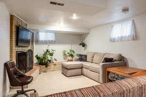 Living room featuring carpet flooring and a brick fireplace