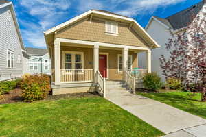 Bungalow-style house featuring a porch and a front lawn