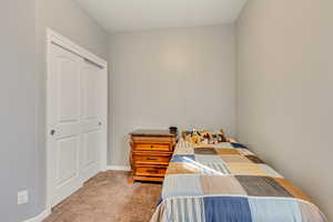 Carpeted bedroom featuring a closet